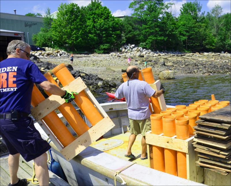 Camden Fire Chief Chris Farley and Chief Deputy Harbor Master Jim Leo load up the fireworks on the gunboat. (Photo by Lynda Clancy)