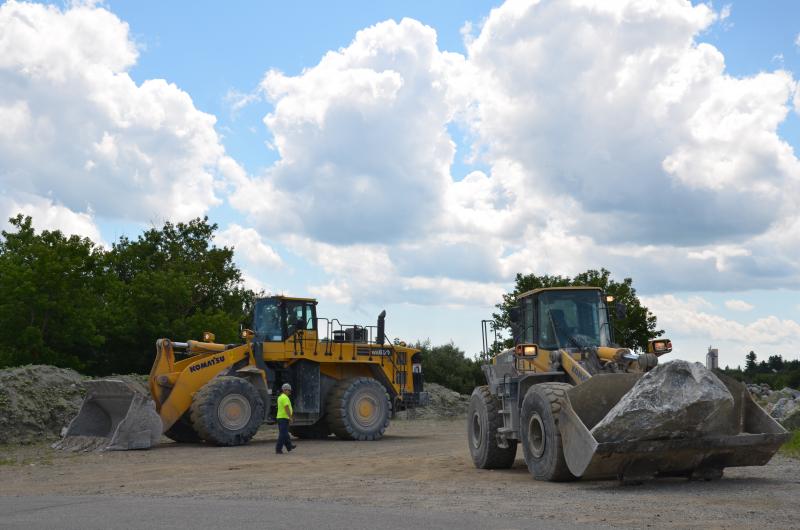 By 2 p.m., Dragon Cement backhoes were placing rocks near the entrance of their quarry-lined property to discourage parking and trespassing. (Photo by Lynda Clancy)