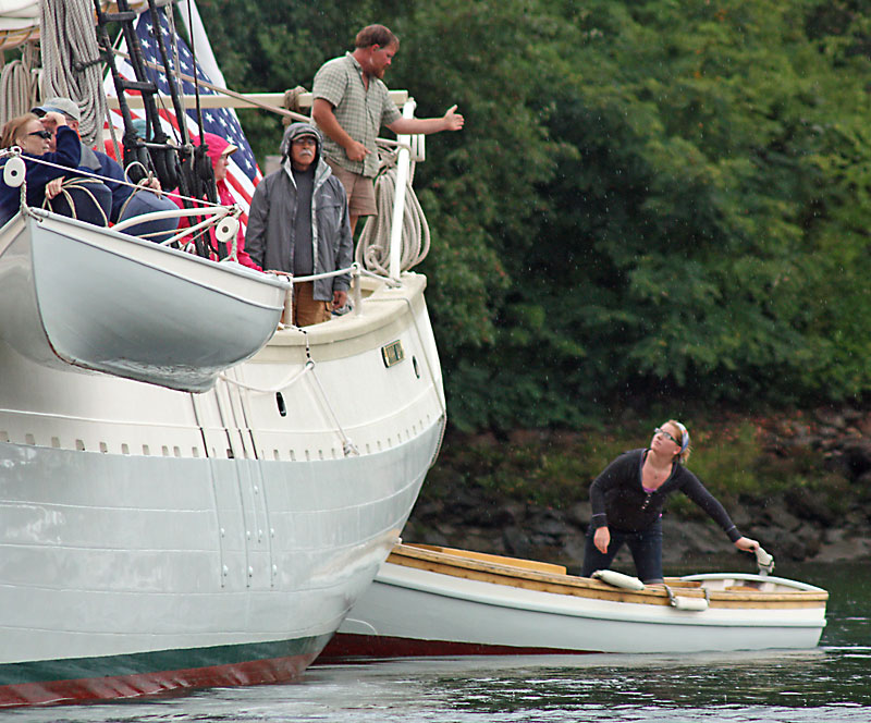 Capt. Barry King of the Mary Day, top center, helps the yawl boat captain maneuver his 125-foot sparred length schooner around the head of Camden Harbor during the start of the 2012 Camden Windjammer Festival. Mary Day is one of at least 18 coastal schooners due in to the harbor this Labor Day weekend for the 2013 Camden Windjammer Festival. (Photo by Holly S. Edwards)