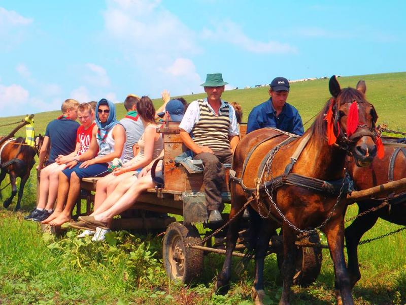 We load onto three carts, legs dangling over the edges, and roll into the surrounding fields. (Photo by Ari Snider)