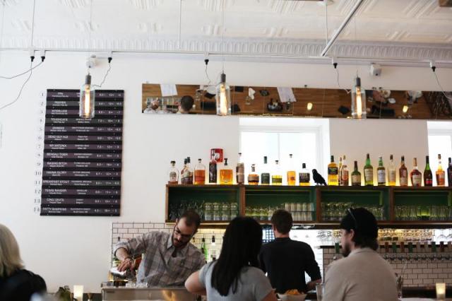 Happy hour at 3Crow's bar with subway tiles and a Grand Central Station train sign for brews. (Courtesy 3Crow)