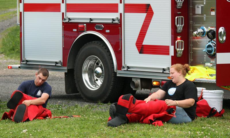 Thomaston firefighters Colby Miles and Jessica Gunn don survival suits in prepration for swimming to rescue victims in the river. (Photo by Holly S. Edwards)