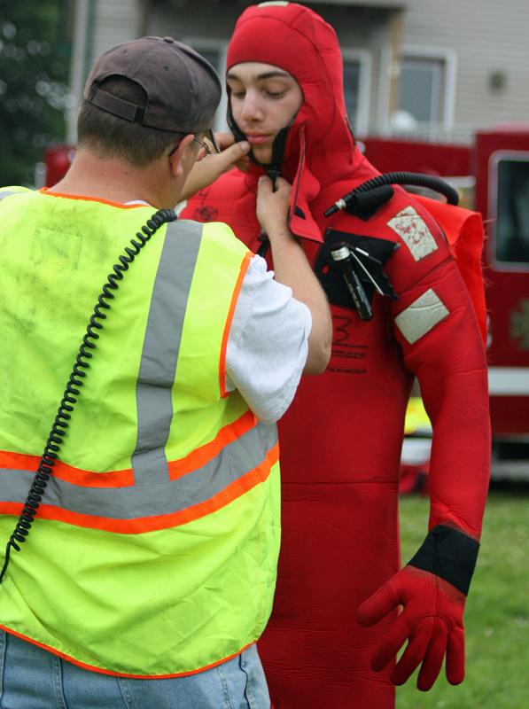Colby Miles get a little help with the velcro closures on the survival suit. (Photo by Holly S. Edwards)