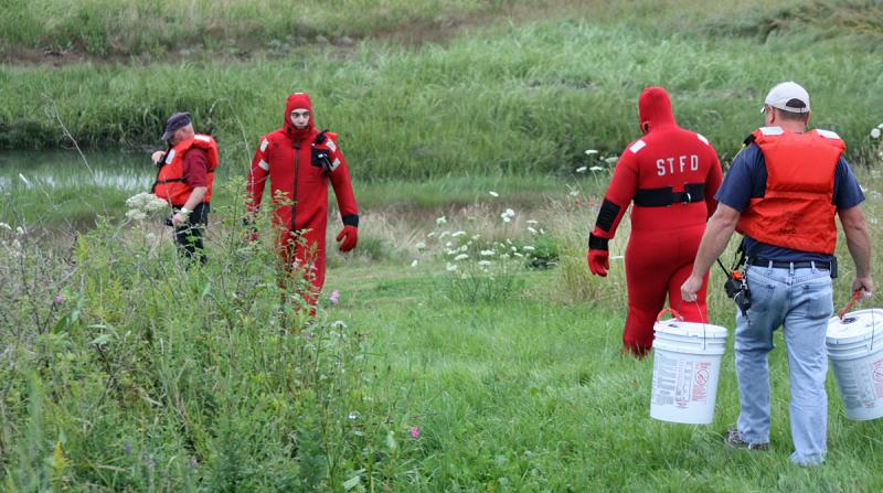 The rescue swimmers from South Thomaston and Thomaston fire departments head to the shore of the river. (Photo by Holly S. Edwards)