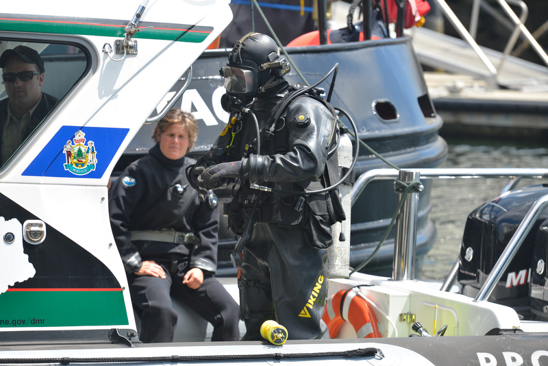 A Maine Marine Patrol diver prepares to enter Rockland Harbor waters to search for a missing diver. (Photo by Ron Hawkes)