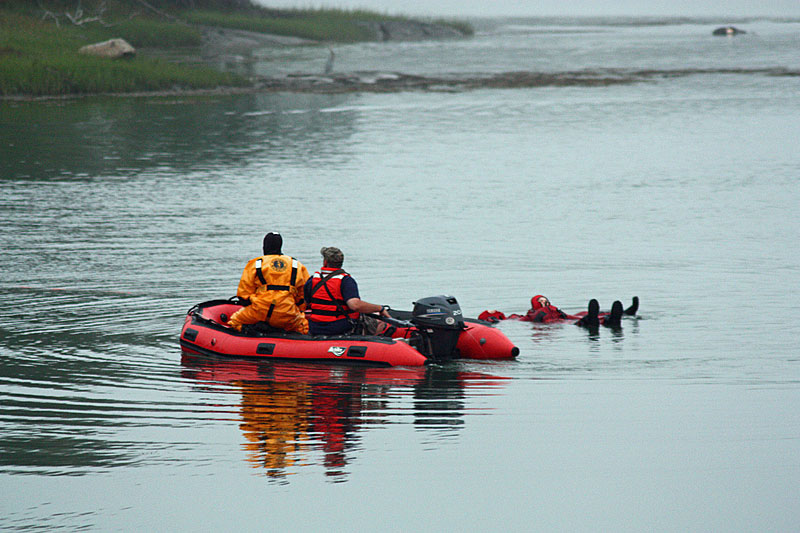 A rescue boat monitors the rescue swimmer and victim, who are being slowly pulled to shore via an unseen rope. (Photo by Holly S. Edwards)