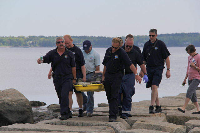 A typical rescue off the Rockland breakwater can require as many as six individuals carrying the patient in a litter and crossing over the same uneven granite blocks that tripped up the patient. (Courtesy Rockland Fire Dept./by Alan Athearn)