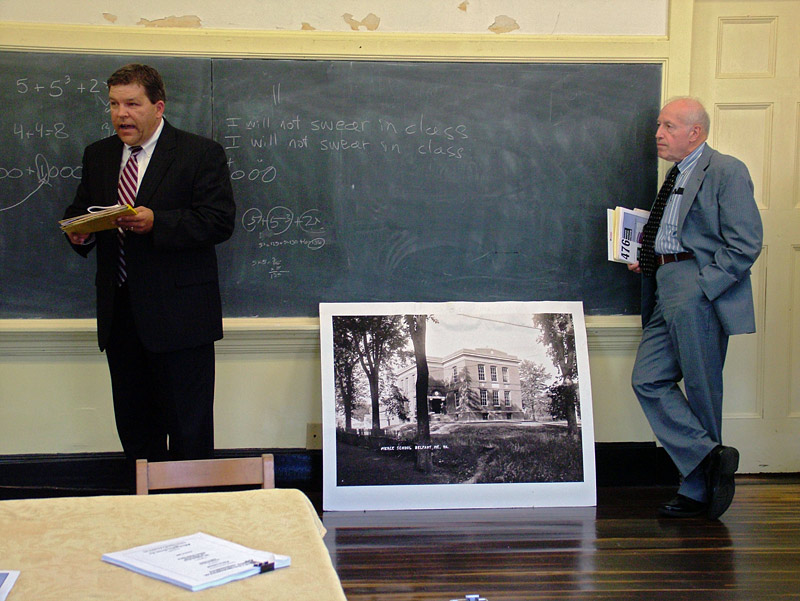 Auctioneer Stefan Keenan tries to solicit bids at a public auction of the former Peirce Elementary School, Aug. 28. At right, the buyer’s representative, who declined to be identified, offered the winning bid of $220,000. (Photo by Ethan Andrews)