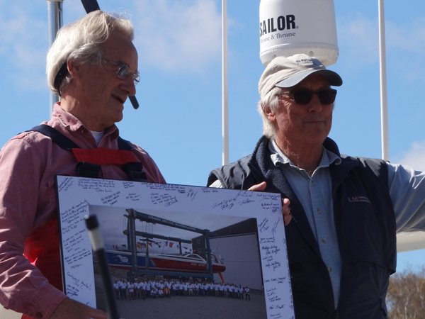 Cabot Lyman, right, told well-wishers at Kiwi Spirit's Sept. 30 departure from Thomaston that this gift from the Lyman-Morse crew would reach St. Augustine before mariner Stanley Paris does. (Photo Shlomit Auciello