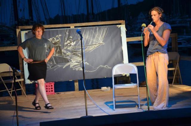 Behind a dancer and fiddler in the Camden Windjammer Festival Schooner Talent Show, Buckley Smith works on one of his drawings, which was auctioned for $500. (Photo by Lynda Clancy)