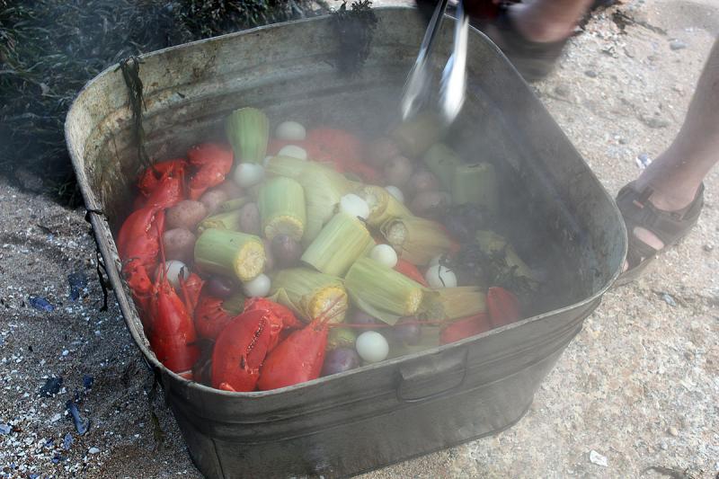 Steaming hot lobsters, corn on the cob, potatoes and onions come off the fire. (Photo by Holly S. Edwards)
