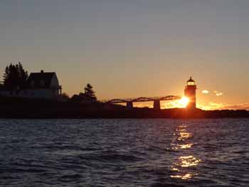 Day breaks behind Marshall Point lighthouse as the lobsterman's day begins. (Photo Shlomit Auciello) Photo Shlomit Auciello