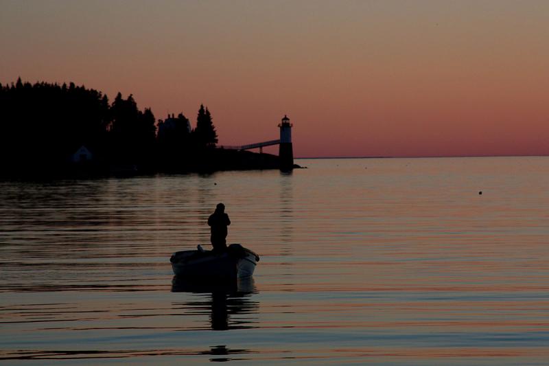 Professional photographer Jim Dugan, also a guest crewman on the Mary Day, glides across the Isle Au Haut thoroughfare as the schooner gets ready to drop anchor for the night. (Photo by Holly S. Edwards)