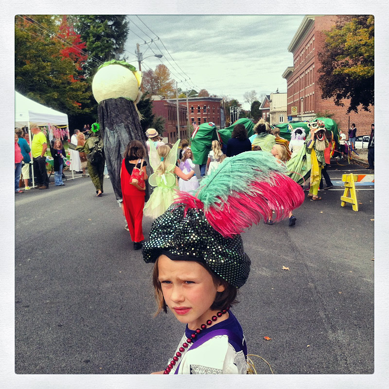 A plumed promenader looks back as the parade heads into town. (Photo by Ethan Andrews)