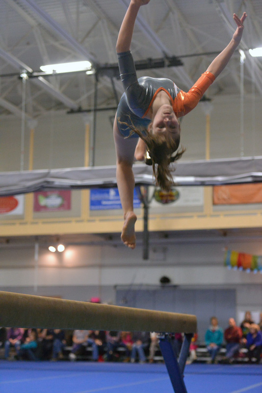 Ashley Kenniston does a backwards flip off the balance beam. (Photo by Ron Hawkes)