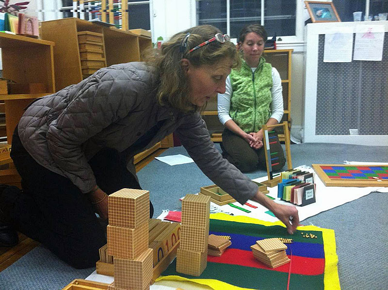Jade Door co-teachers Katy Hall Dermott and Darci Grotton, background, explain ways that students are taught about the decimal system. (Courtesy Children's House Montessori School)