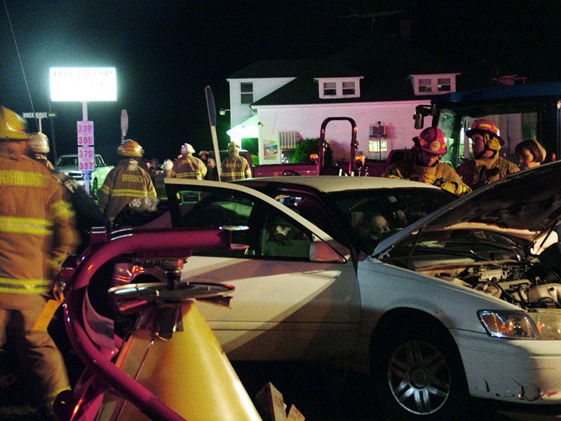 Firefighters work to free the driver of the Toyota Camry from his vehicle roughly 45 minutes after the crash. (Photo by Ethan Andrews)