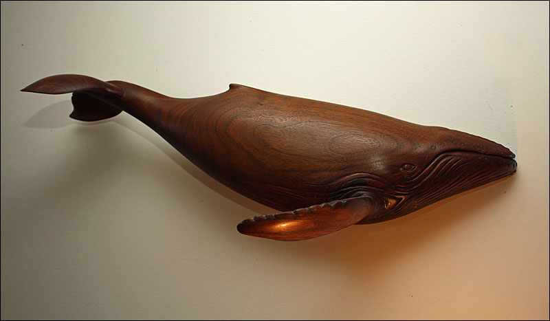 Artist and illustrator Ben McGinnis is especially fond of this whale he carved from a piece of black walnut, one of his first attempts at carving. (Photo by Holly S. Edwards)