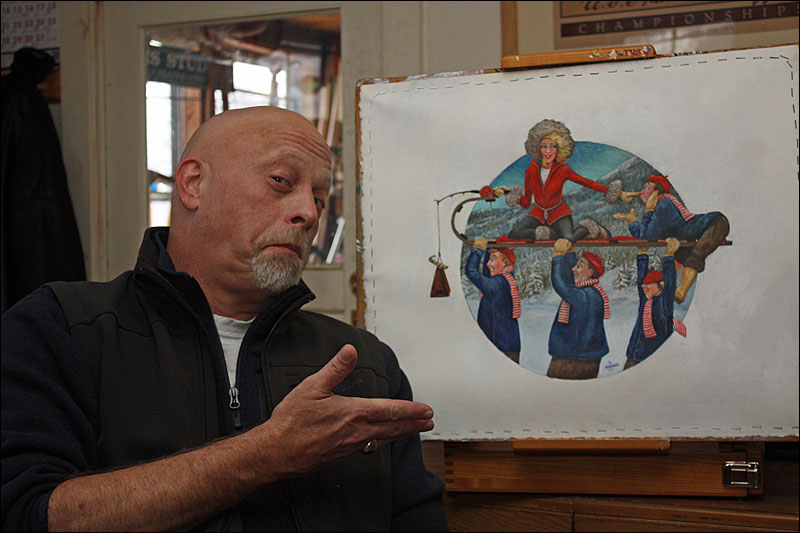 Graphic illustrator and artist Ben McGinnis of Hope with the original painting for the 2014 U.S. National Toboggan Championships poster, T-shirt and event guide cover. He spent months painting it, in his free time, on this easel in his kitchen, moving a chair from the table to the easel and swiveling a ceiling light over for the detail work. (Photo by Holly S. Edwards)