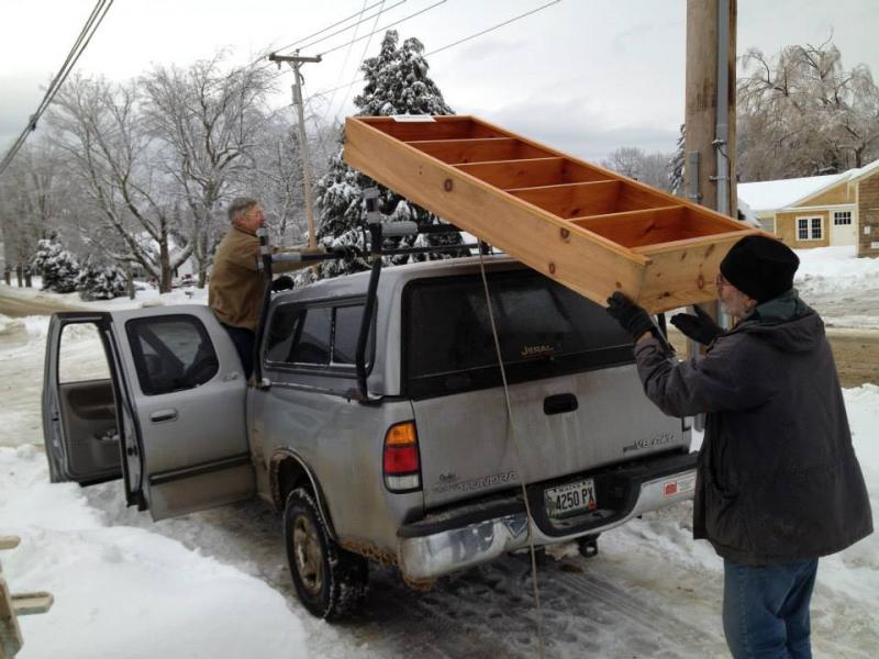 Doug Thompson and Tom May unload one of the library's many bookcases. (Courtesy Lincolnville Community Library)