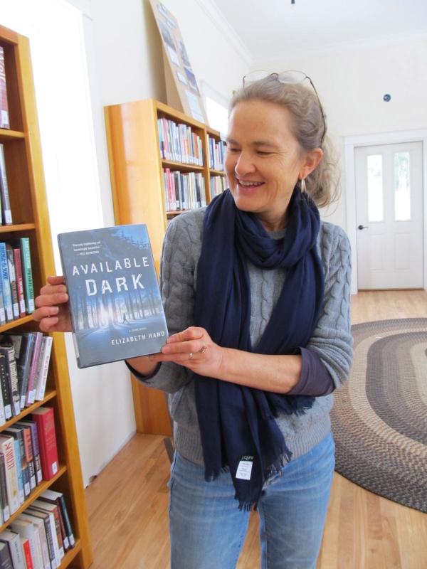 Many Lincolnville authors have donated their own books to the library. Here’s Sheila Polson holding up Elizabeth Hand’s latest novel. (Photo by Kay Stephens)