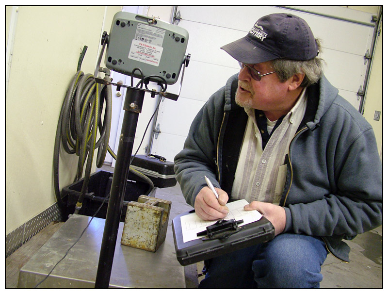 Wiggin checks the reading on a large scale at Maine Maritime Products in Belfast. On the scale bed is a single 50 pound weight. (Photo by Ethan Andrews)