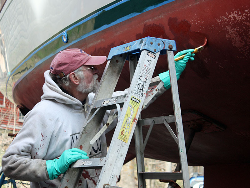 Capt. Jack Moore paints the bottom of he and his wife, Barbara’s, 35-foot sloop, Milky Way, which they will now spend summers sailing around Penobscot Bay. (Photo by Holly S. Edwards)