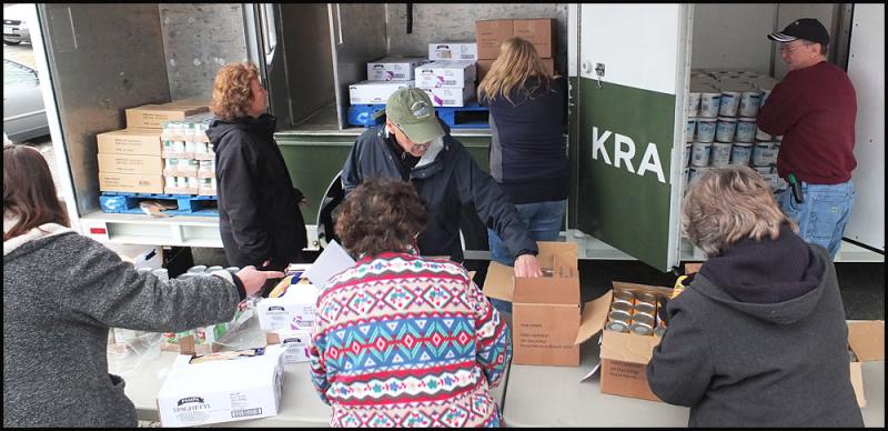 Volunteers organize donated food at the start of the Area Interfaith Outreach Food Pantry’s mobile food give-away. (Photo by Chris Wolf)