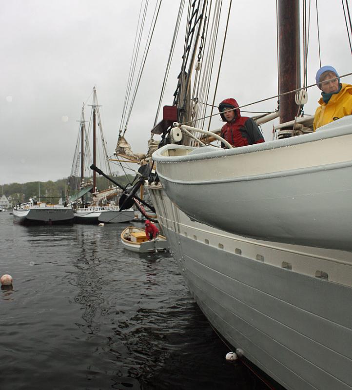 Schooner Mary Day First Mate Rebecca Johnson mans one of the small boats to begin moving the big engine-less schooner out of Camden Harbor Wednesday morning. (Photo by Holly S. Edwards)
