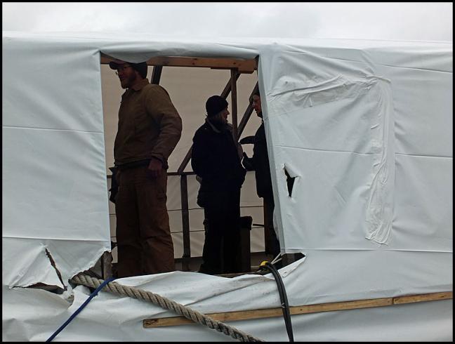 People gather under the shrinkwrap over the schooner Nathaniel Bowditch earlier this year before the public auction of the boat in which there were no bidders. (Photo by Chris Wolf)