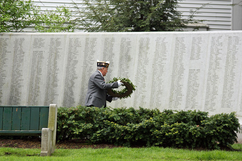 Ray Lewis delivers a wreath to Camden’s honor roll in the village green Monday during the a pause in the parade. (Photo by Holly S. Edwards)