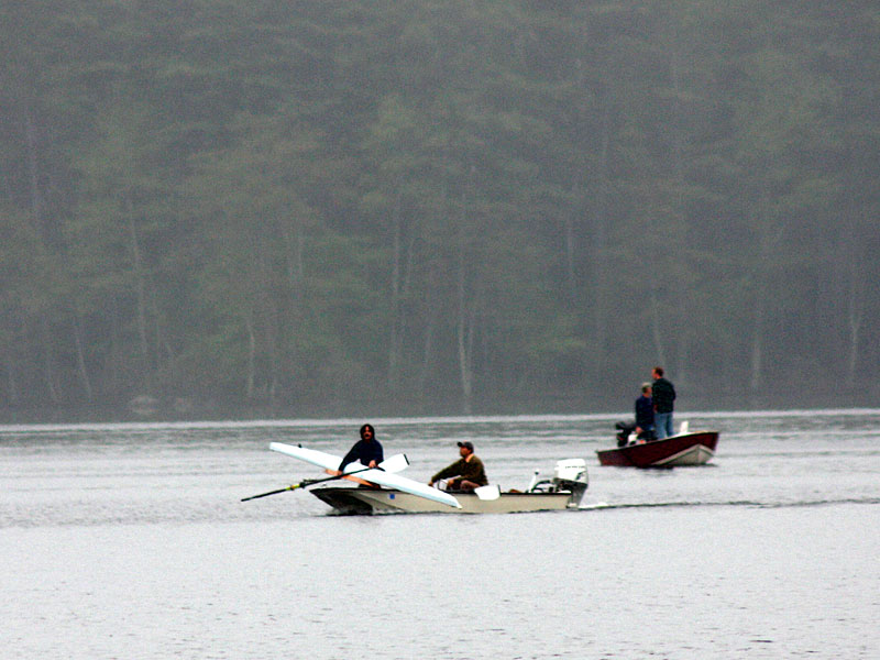 The missing rower’s sculling boat is carried back across Megunticook Lake. (Photo by Holly S. Edwards)