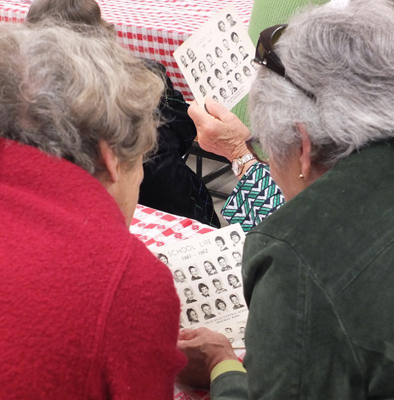 People pour over photos, searching for when they were in school at Owls Head Central School. (Photo by Chris Wolf)