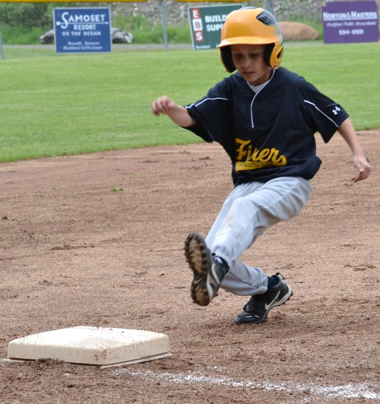 A Fisher player slides into third base. (Photo by George Harvey)
