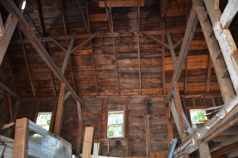 The barn roof soars over old horse stalls.