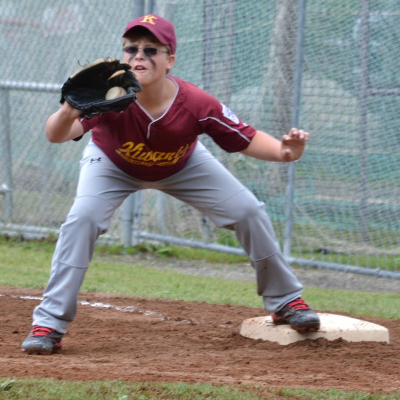 Ethan Carballo, of Kiwanis, receives the throw and therefore, gets the base runner out. (Photo by George Harvey)
