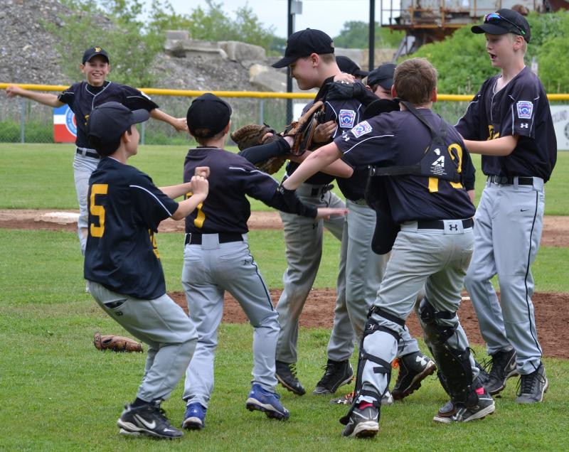 Several Fisher players celebrate immediately following the final out. (Photo by George Harvey)