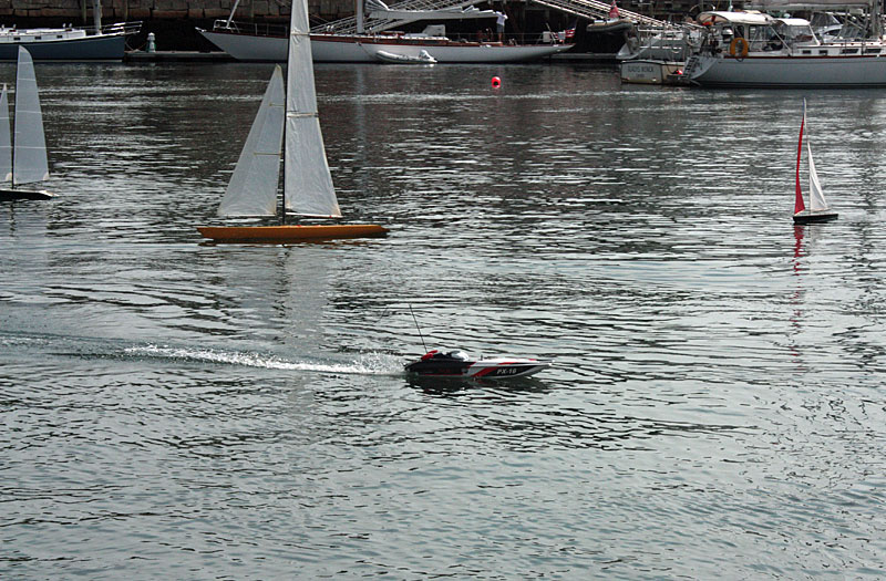 An RC power boat rushes through the field of RC sailboats during one of Sunday’s race heats. (Photo by Holly S. Edwards)