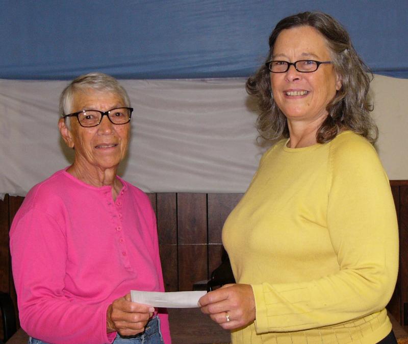 Charlotte Gulezian of the Waldoboro Women’s Club Scholarship Fund accepts a donation check from Sally Lobkowicz of Wolliker’s Waldoboro Whimsies.