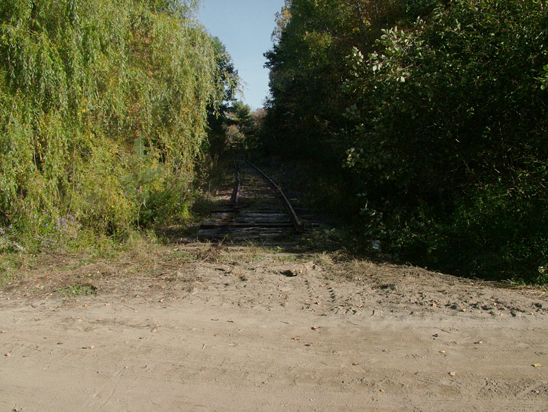 The tracks of the old Belfast & Moosehead Lake Railroad end abruptly at the old Upper Bridge crossing, the area designated as one end of a planned recreational trail along the Passagassawakeag River. Workers started removing the rails this week along a two-mile stretch of the city-owned corridor. (Photo by Ethan Andrews)