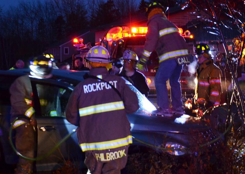 Rockport firefighters scramble to extricate a woman from a car involved in crash on Route 90 in Rockport Saturday evening, Nov. 1. (Photo by Lynda Clancy)