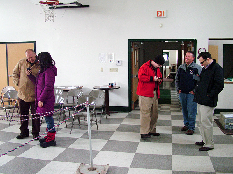 State Senator Michael Thibodea (R-Winterport), second from right, and challenger Jonathan Fulford (D-Monroe), far left, wait with supporters at the Waldo town office, Wednesday, Nov. 6. Due to storm damage, the office had no heat or power. Poll workers closed shop Tuesday night and returned on Wednesday to hand count the last of the county’s ballots. (Photo by Ethan Andrews)