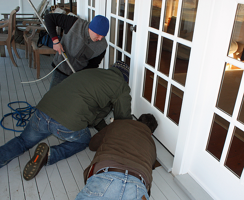 Slowly, Lucy begins to appear from below the deck and Mike Sabatini, center, then reaches down to make sure she doesn’t fall back in. (Photo by Holly S. Edwards)