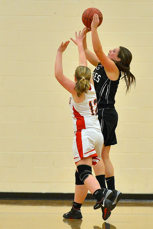 Lincoln Academy’s Kortney mckenna, right, gets fouled on this shot and makes her second foul shot to win the game for the Eagles. (Photo by Ron Hawkes)