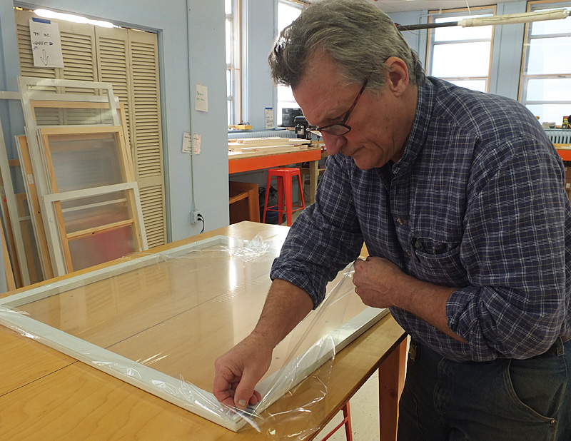 Jay Hoagland finishes adding plastic to a window insert before sending it off the oven.