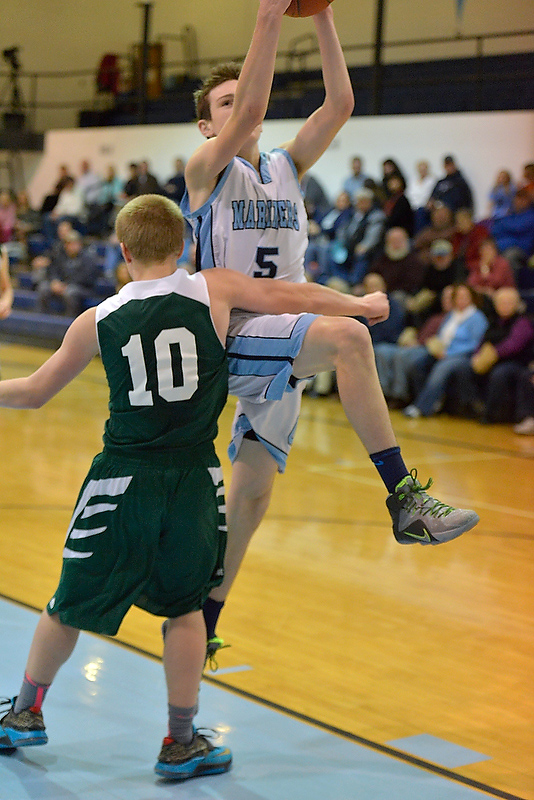 Oceanside’s Michael Norton, right, made a nice move on this layup attempt, but was called for the player control foul on Mount View’s Kalvin Croteau. (Photo by Ron Hawkes)