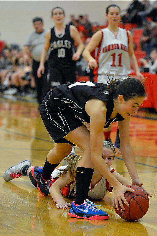 Lincoln Academy’s Marta Berta, top, plays some tough defense on a loose ball as she steps over Camden’s Laticia Billings to pick up the ball. (Photo by Ron Hawkes)