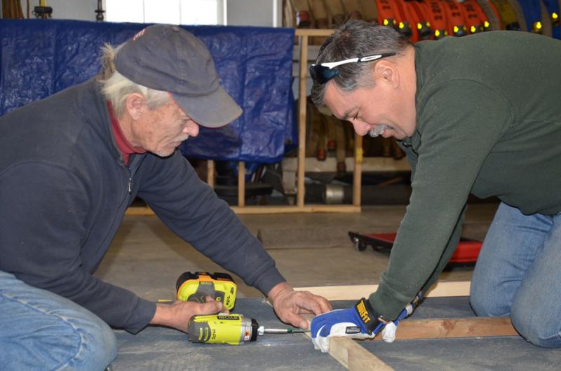 Rockport firefighters Michael Callaway and John Sylvester measure the framing for a new ice shack built for military veterans. (Photo by Lynda Clancy)