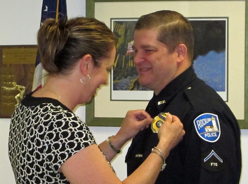 Rockland Police officer Joel Neal receives a new shield, from his wife, Heidi, denoting him as a detective for the department. (Courtesy Rockland Police Department)