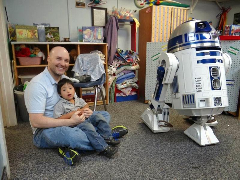 Paul Bussiere with a child from Kids' Corner-Community Early Care and Learning Facility in Bar Harbor and his home built R2-D2 droid unit. (Photo courtesy Paul Bussiere)